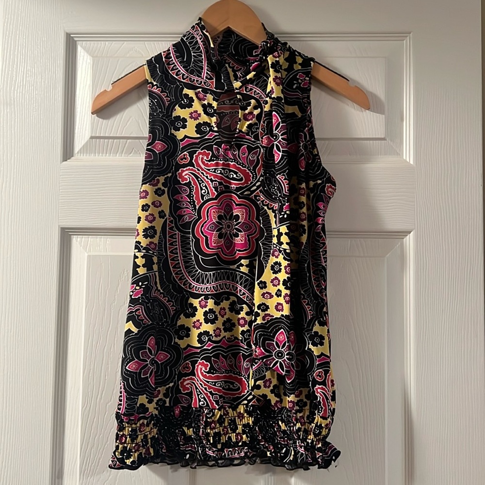 High neck sleeveless top with small opening in the front.
